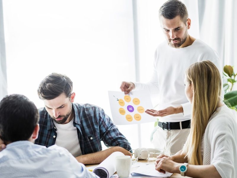 businessman-showing-chart-his-female-employee-workplace
